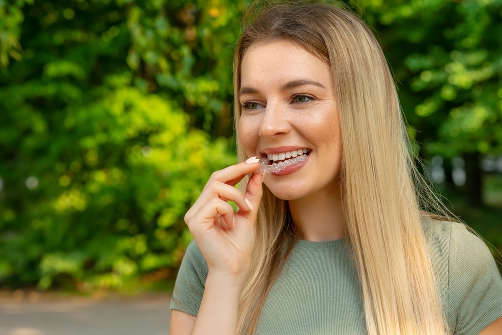 Girl puts a dental retainer on her teeth